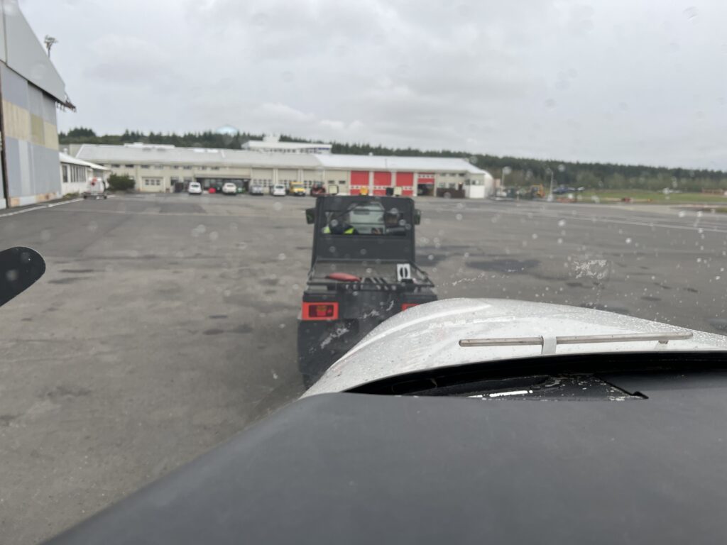 Cockpit view of an aircraft tug in front and pulling the aircraft